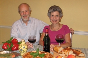 Sara and her husband, Al, at a table with food and wine